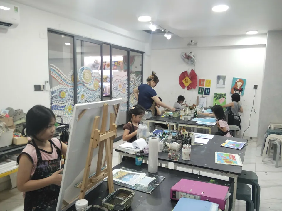 Teacher guiding students in a bilingual art class at 24 Art Tan Phu