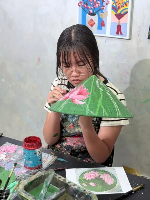 Students joining a conical hat painting workshop in Tan Phu